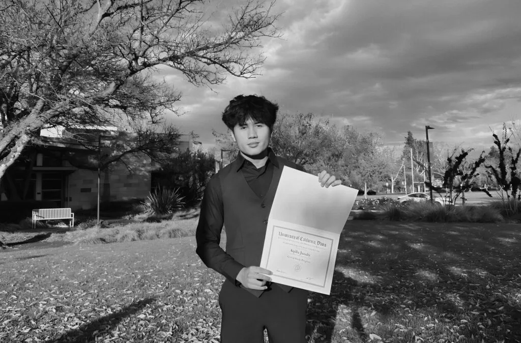 Aqeel holding his certificate at the University of California, Davis